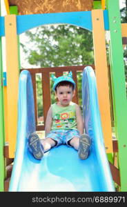 Little boy on a blue slide