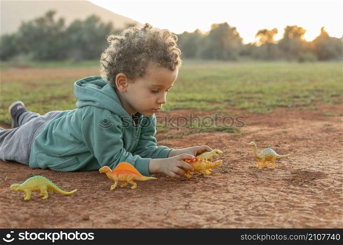 little boy outdoors playing with toys