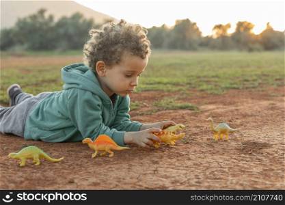 little boy outdoors playing with toys