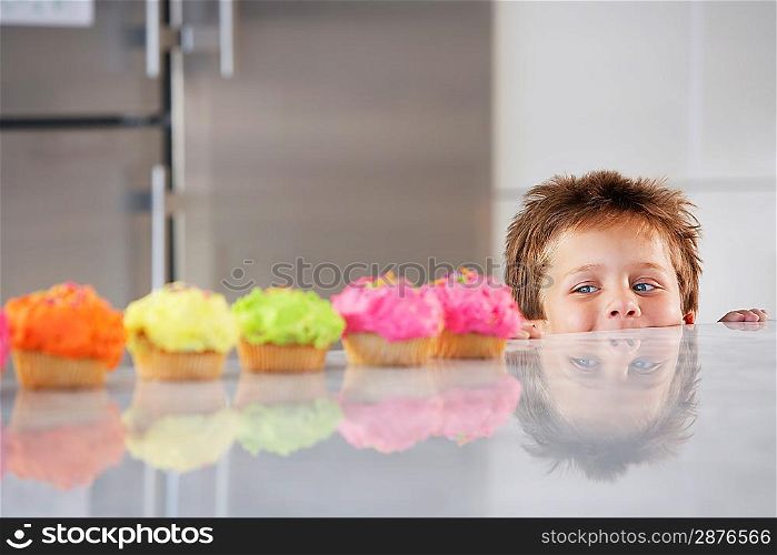 Little Boy Peeking at Cupcakes