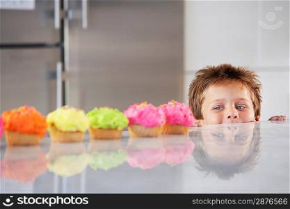 Little Boy Peeking at Cupcakes