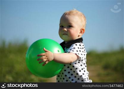 little boy play in green grass with green ball