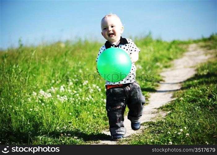 little boy play in green grass with green ball