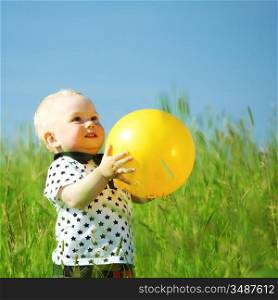 little boy play in green grass with yellow ball