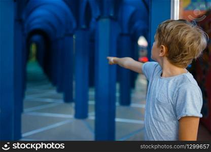 Little boy playing in terrible labyrinth, playground in entertainment center. Play area indoors, playroom