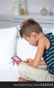Little boy playing video games on sofa