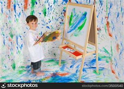 Little boy playing with painting with the background painted