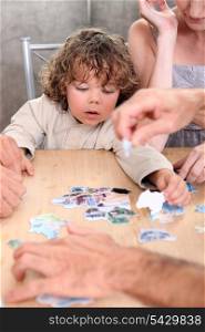 Little boy playing with pictures at a table