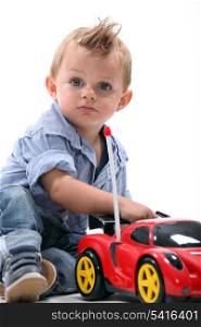 little boy playing with toy car