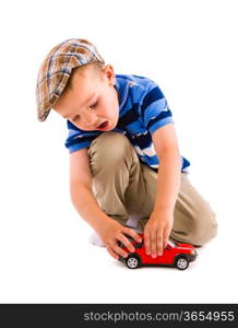 Little boy plays with red toy car, white background