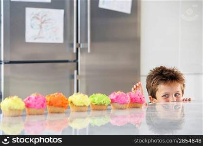 Little Boy Reaching for a Cupcake