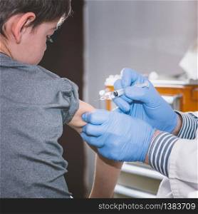 Little boy receives a vaccination in the doctors office.