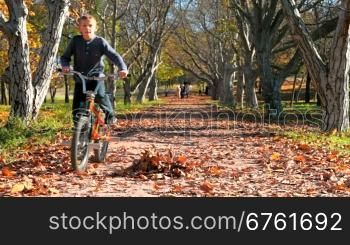 little boy riding his bike on a sunny autumn day