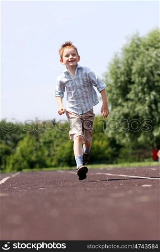 little boy runs in a summer park
