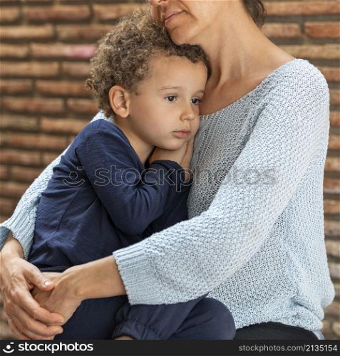 little boy sad comforted by his mother