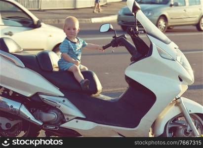 Little boy seat on big bike