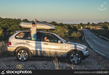 Little boy show up on car window. Tourist car on the road. Travel concept with child.