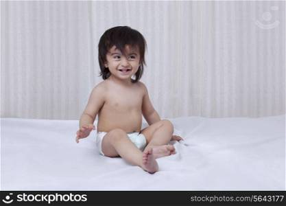 Little boy sitting on a bed
