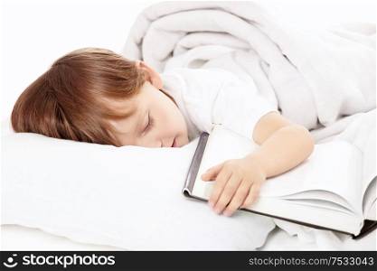 Little boy sleeps in bed embracing the book, isolated