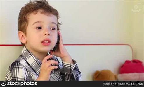 Little boy talking on smartphone at home