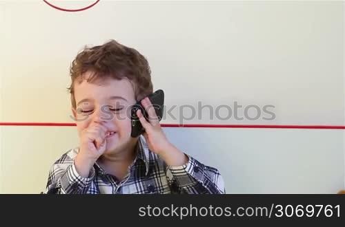 Little boy talking on the smartphone at home