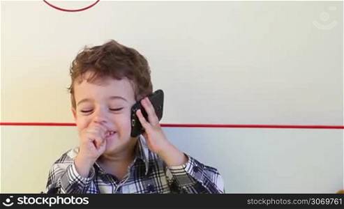 Little boy talking on the smartphone at home