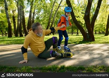 Little boy teaching old grandfather roller skating in park. Granddad falling down on road and grandson helping him to stand up. Joyful time together, happy childhood and parenting. Little boy teaching old grandfather roller skating in park
