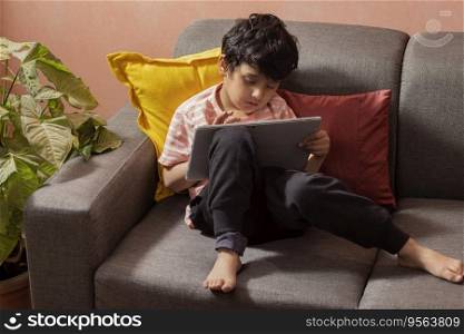 Little boy using a digital tablet in living room
