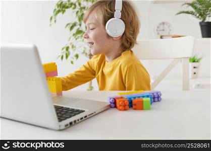little boy using headphones laptop home