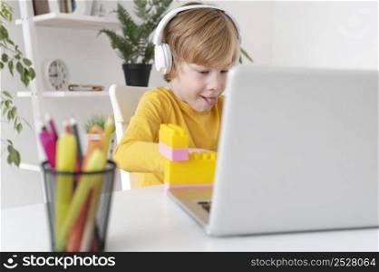 little boy using laptop headphones home