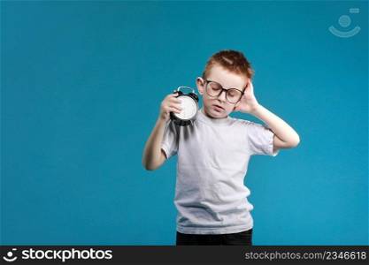 Little boy waking up with alarm clock, isolated on the blue background. Define your own rhythm of life. Happy hours concept. Schedule and timing.. Little boy waking up with alarm clock, isolated on the blue background. Define your own rhythm of life. Happy hours concept. Schedule and timing