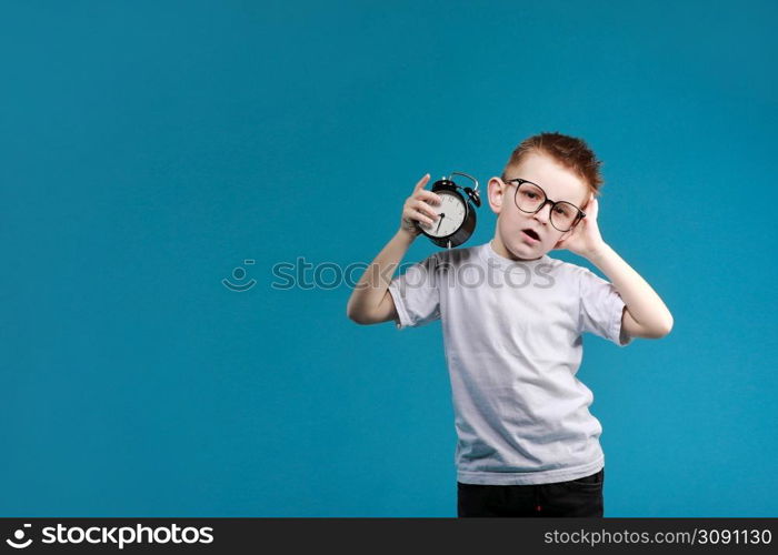 Little boy waking up with alarm clock, isolated on the blue background. Define your own rhythm of life. Happy hours concept. Schedule and timing.. Little boy waking up with alarm clock, isolated on the blue background. Define your own rhythm of life. Happy hours concept. Schedule and timing