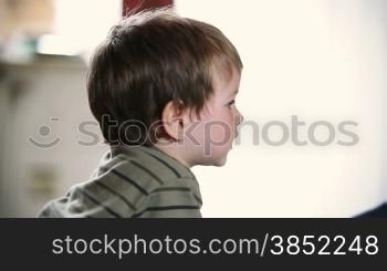 Little boy watching TV, side view