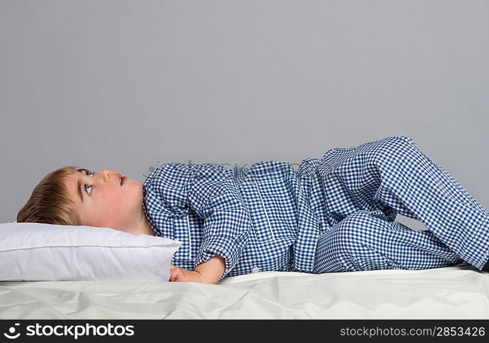 Little boy wearing blue pyjamas in bed