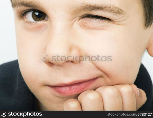 Little boy wink of an eye. Close up studio shot