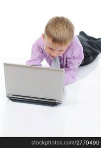 little boy with a laptop lying on the floor in a bright room. Isolated on white background