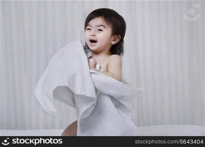Little boy with a towel covering him
