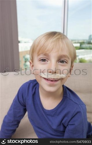 Little boy with artificial mustache smiling