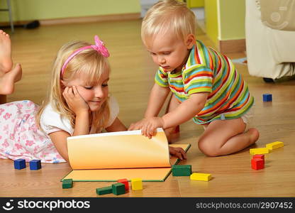 little boy with his sister playing at home