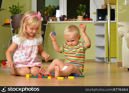 little boy with his sister playing at home