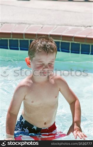 Little boy with irratated eyes in swimming pool