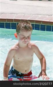Little boy with irratated eyes in swimming pool