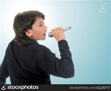 Little boy with microphone sings a song. on a blue background