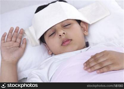 Little boy with wet cloth on forehead sleeping