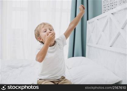 little boy yawning after waking up