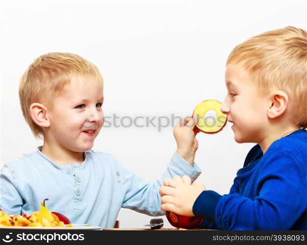 Little boys children brothers preschooler peeling fruit apple eating cooking at home. Happy childhood.