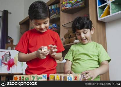 Little boys playing with wooden toy blocks