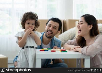 Little Caucasian kid girl trying to blow a pink balloon with puffy cheeks expression while parent is cheer their child to do it by herself. Mixed race family celebrate for move to new house together