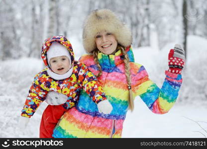 Little cheerful girl on a winter walk in the snow