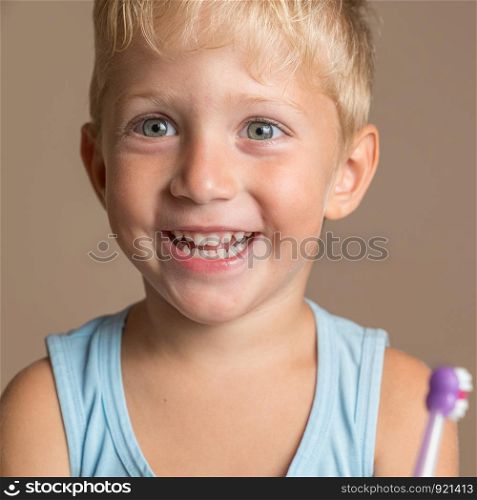 little child boy with tooth brush,kid boy smiling happiness,dental hygiene and health for children,brown background.